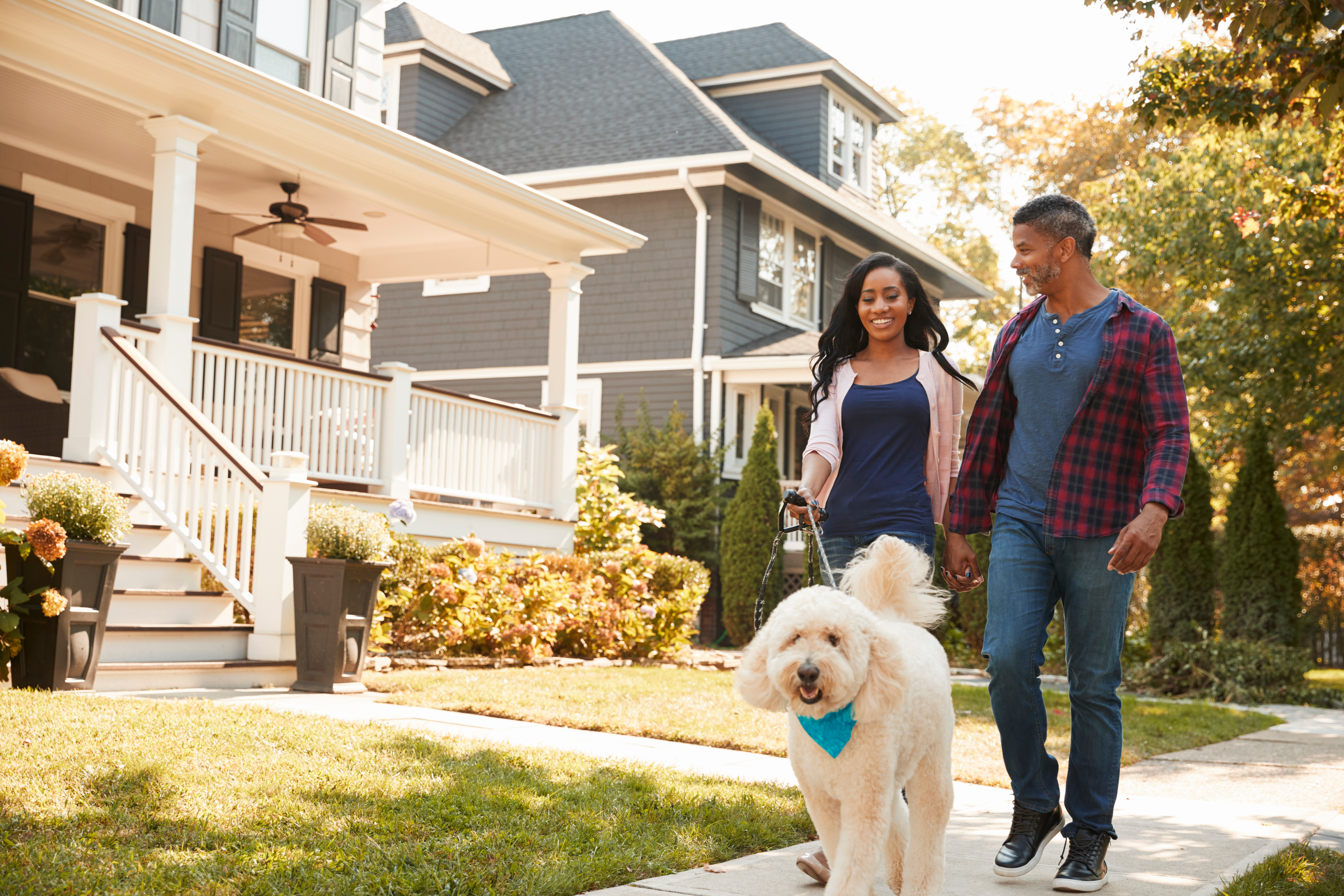 couple walking dog in neighborhood